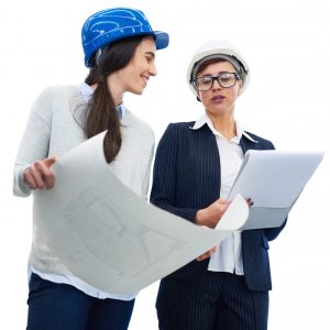 Confident female technologist in hardhat examining document while engineer showing blueprint in factory